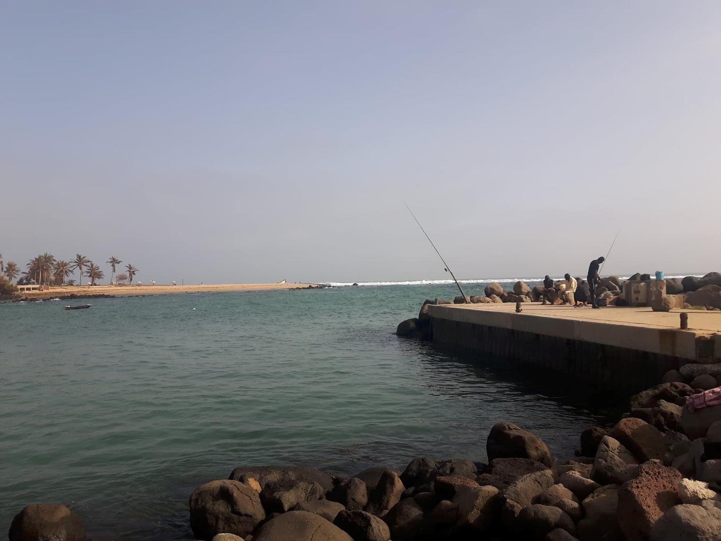 Une image du port de Dakar entouré de petits cailloux et faisant façe à une autre ile.