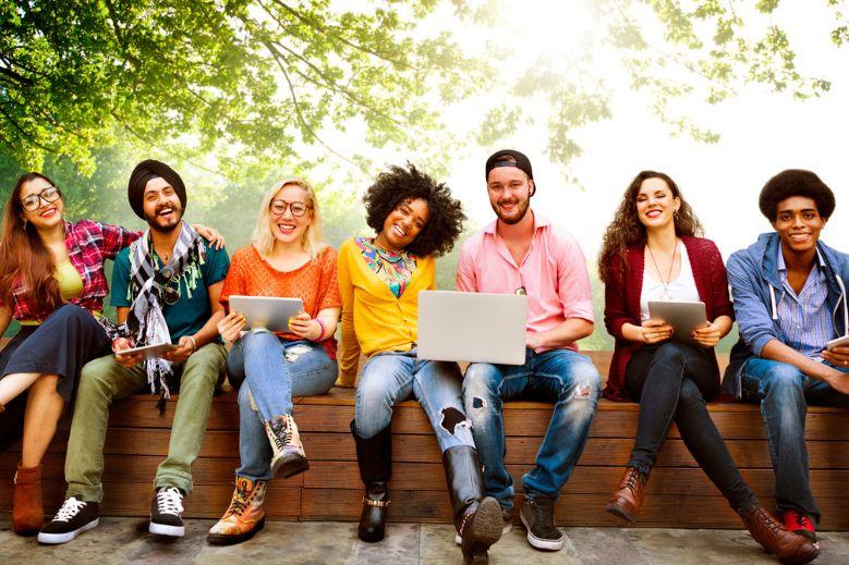 Group d'étudiants assis sur un banc dehors 