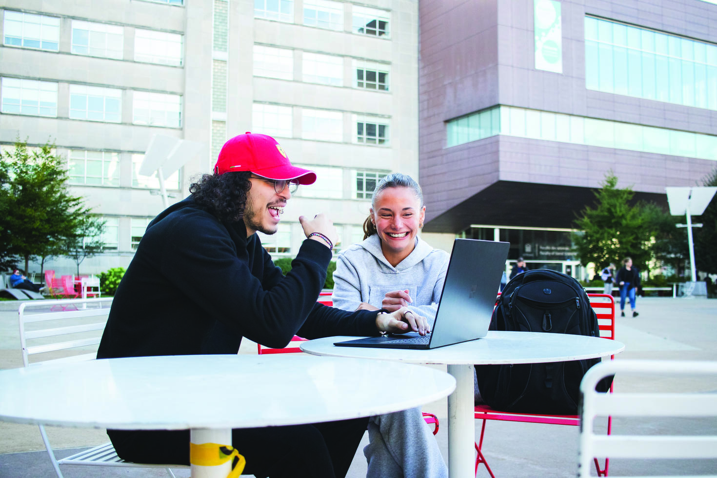 DEux étudiants assis à une table à l'extérieur du pavillon FSS
