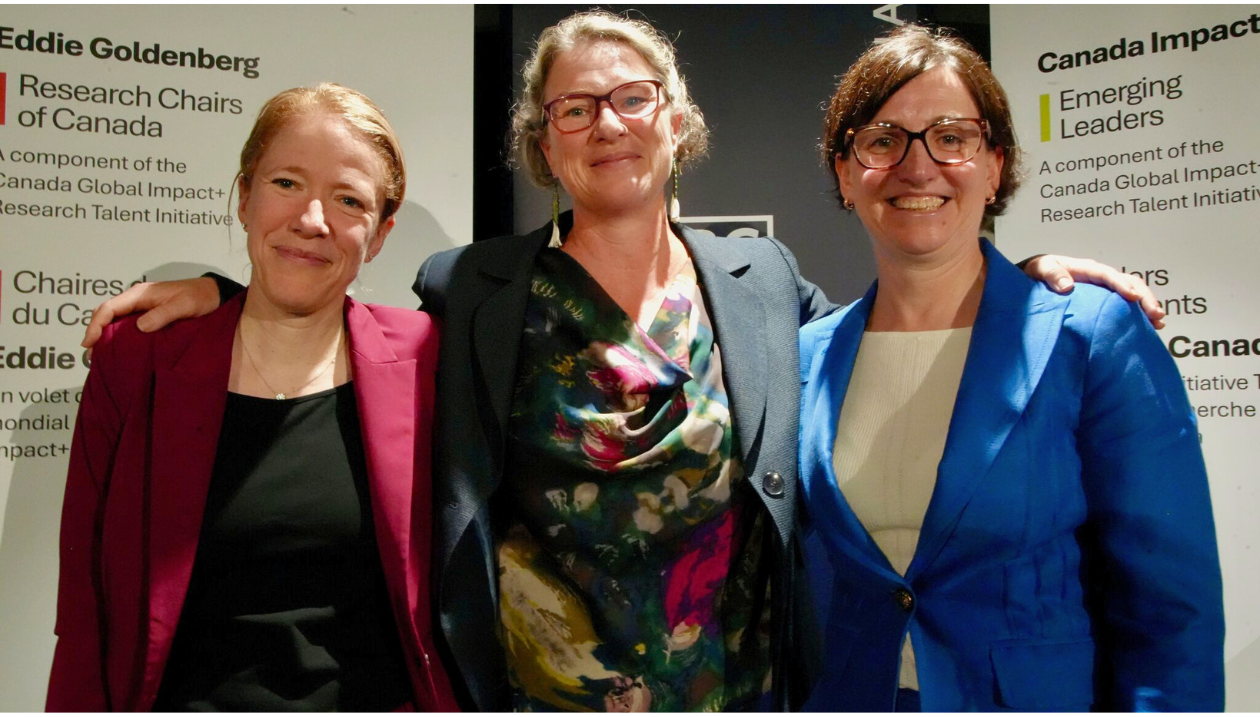 Trois femmes debout côte à côte et souriantes lors d’un événement soulignant les Chaires de recherche du Canada Eddie Goldenberg.