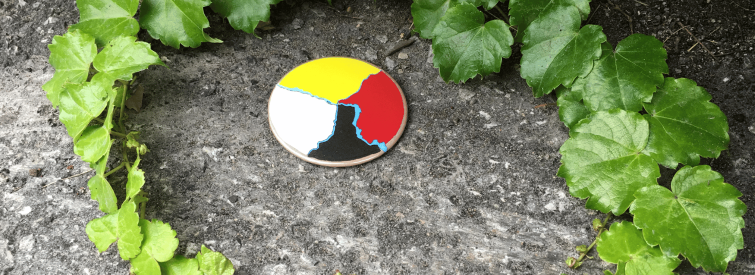 Roue médicinale entourée d’un cercle de verdure sur la roche grise