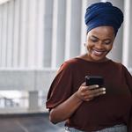 Black woman with a red top and blue braids smiling