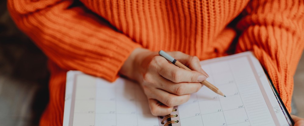 Personne écrivant dans un agenda