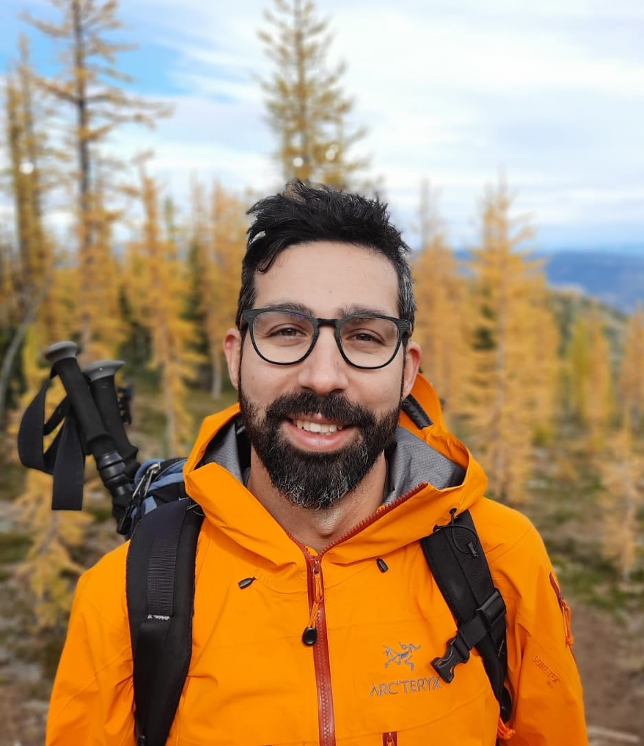Le professeur Yaseen Mottiar avec un imperméable jaune en randonnée dans les bois.