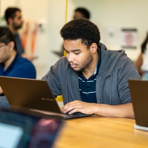 Un étudiant regarde son écran d'ordinateur. 