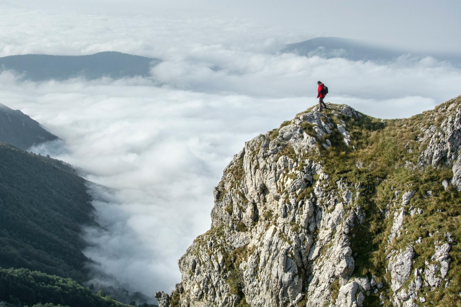 Personne debout au sommet d'une montagne