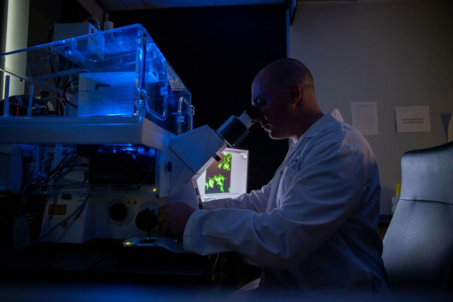 Male scientist looking into a microscope