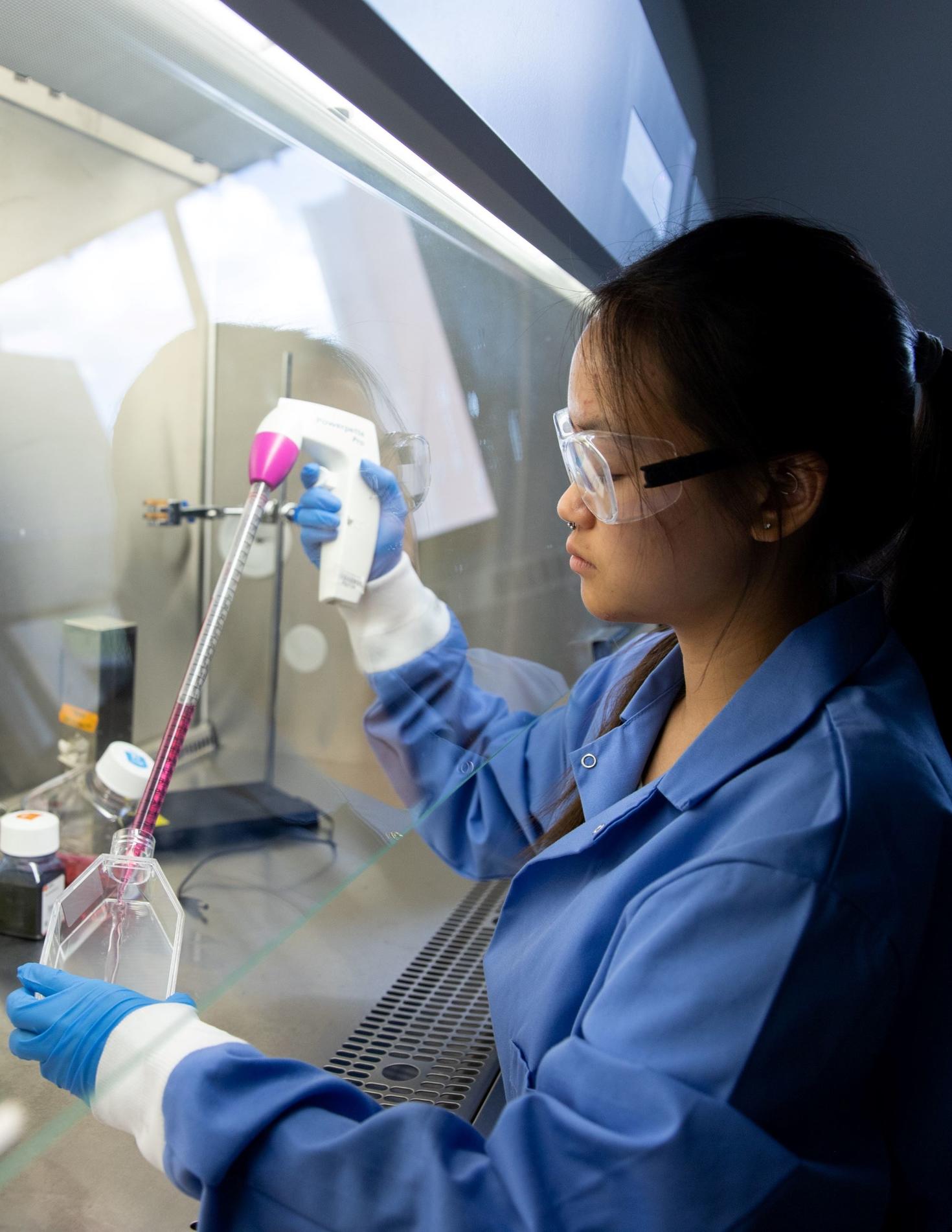 Étudiante travaillant sous une hotte aspirante dans un laboratoire