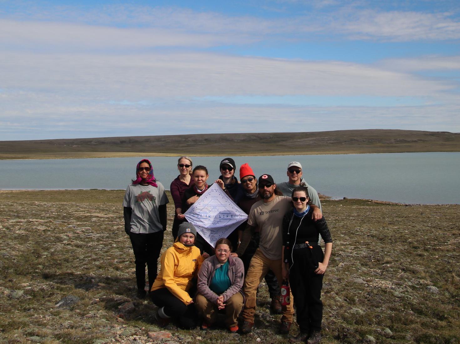 Le professeur Jules Blais et son équipe posant devant le lac « ERA-5 » près de Cambridge Bay, île Victoria, Nunavut.