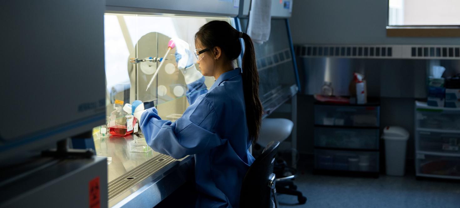 Étudiante travaillant sous une hotte dans un laboratoire de chimie