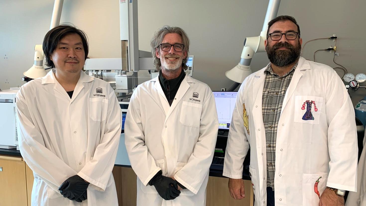 (De gauche à droite) Rui Liu, gestionnaire de laboratoire et analyste principal pour RADAR, le professeur Cory Harris et le professeur Adam Shuhendler, en sarraus devant leur équipement de laboratoire.