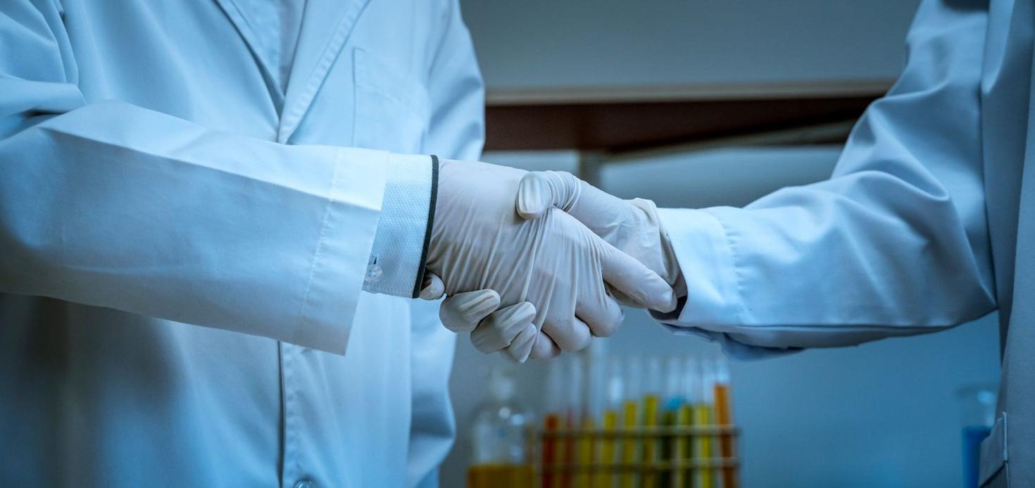Les scientifiques se serrent la main pour symboliser leur collaboration dans la recherche et l'expérimentation. 
