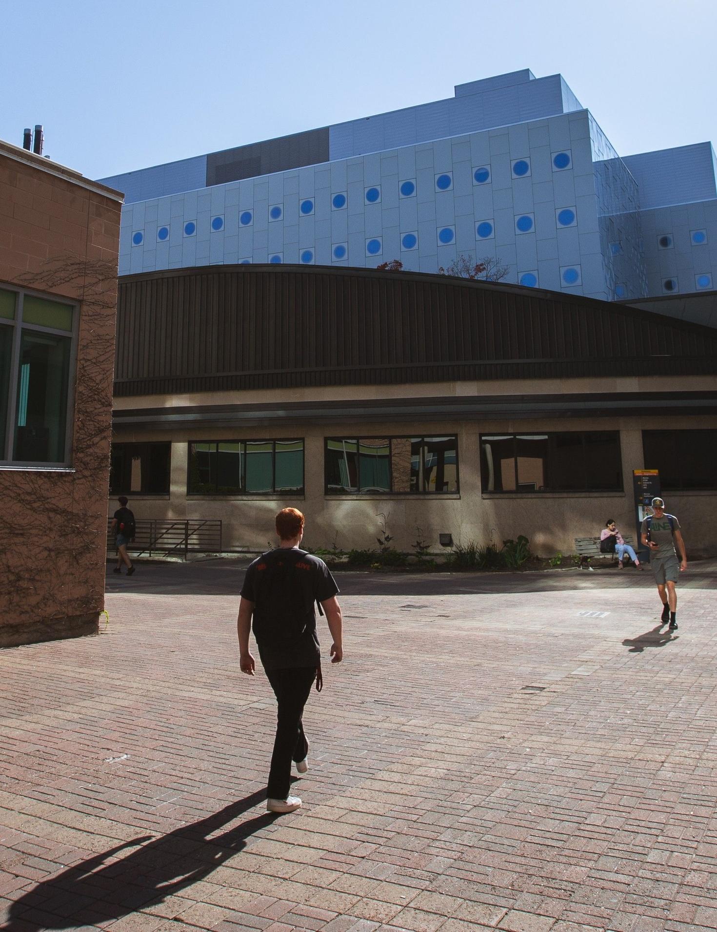 Un étudiant se dirigeant vers le complexe dédié aux STEM sur le campus.