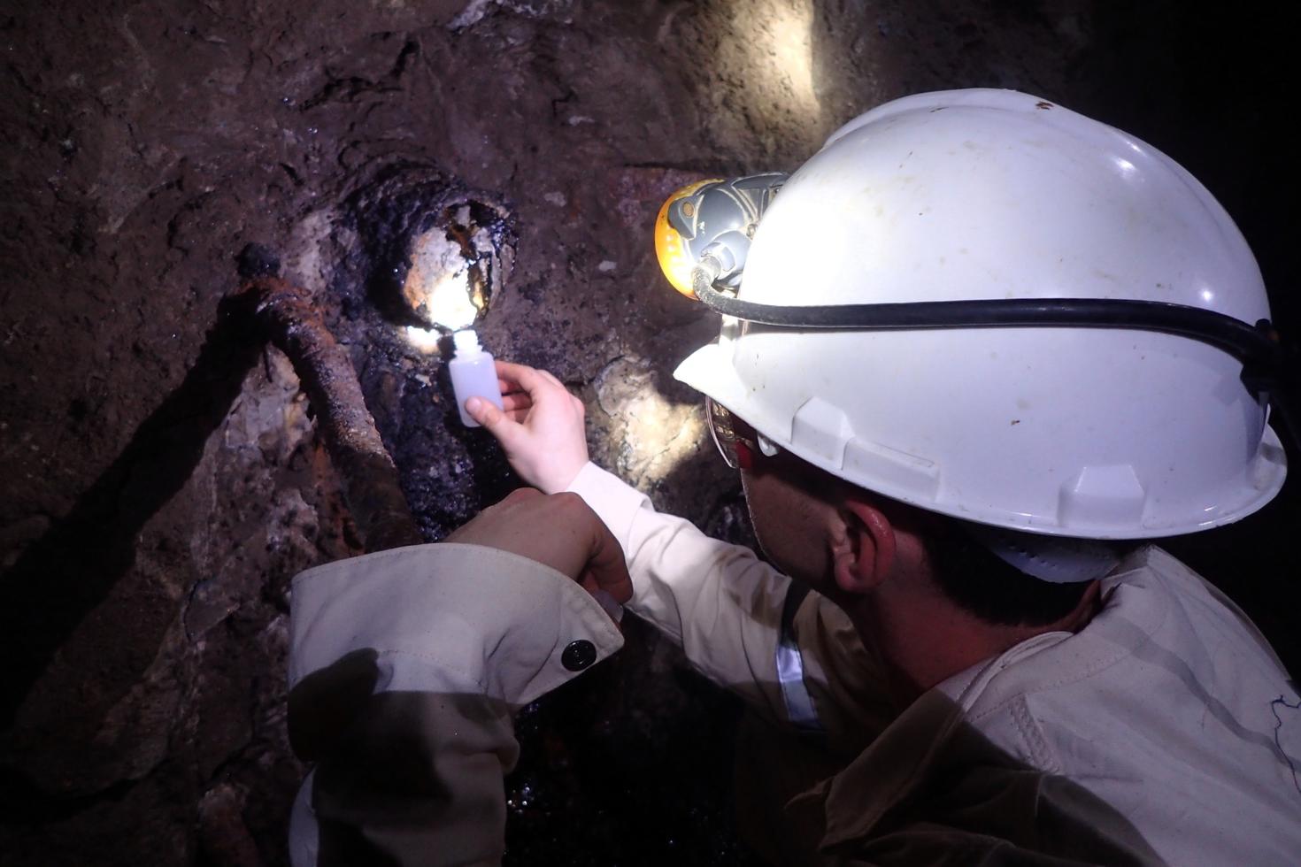 Un chercheur prélevant un échantillon dans une mine. 