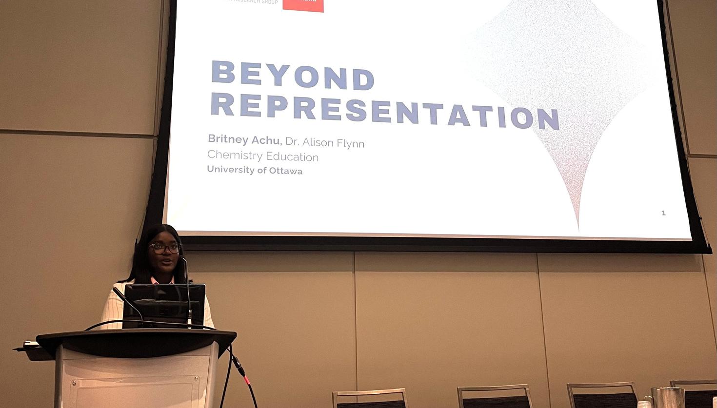 Britney Achu prend la parole lors d'une conférence, debout derrière un podium.