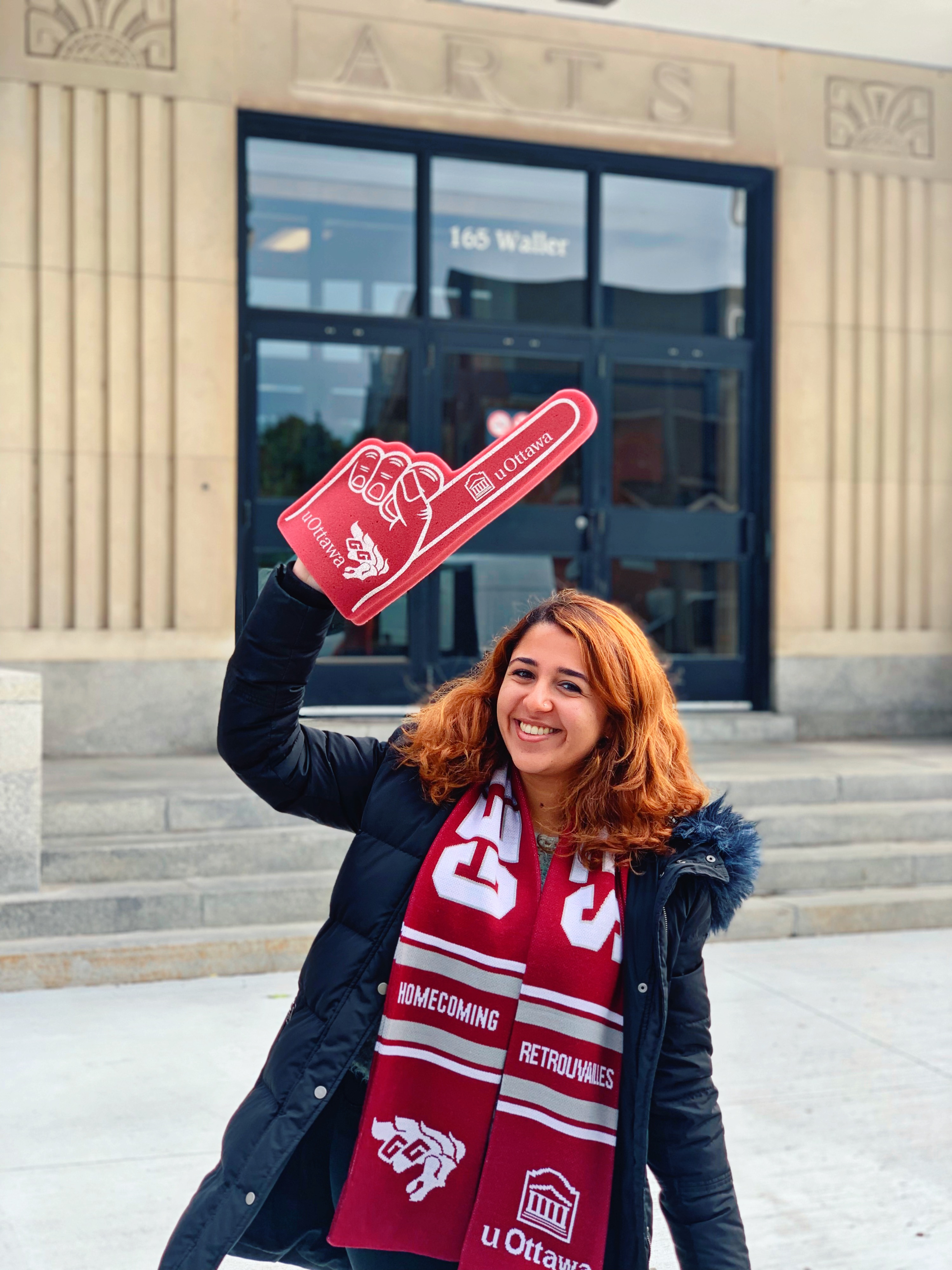 Person wearing uOttawa merch with a uOttawa foam finger