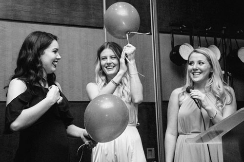 Students on stage holding balloons.