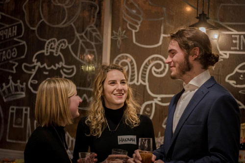 Students chatting over wine and cheese.