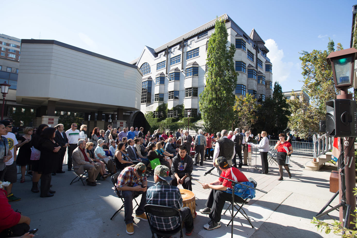 Crowd beginning to gather outside a large building on the university campus