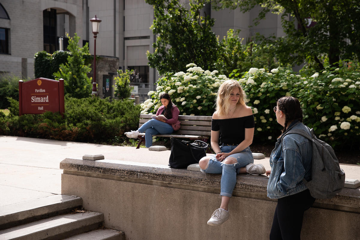 Students sitting outside of Simard Hall.