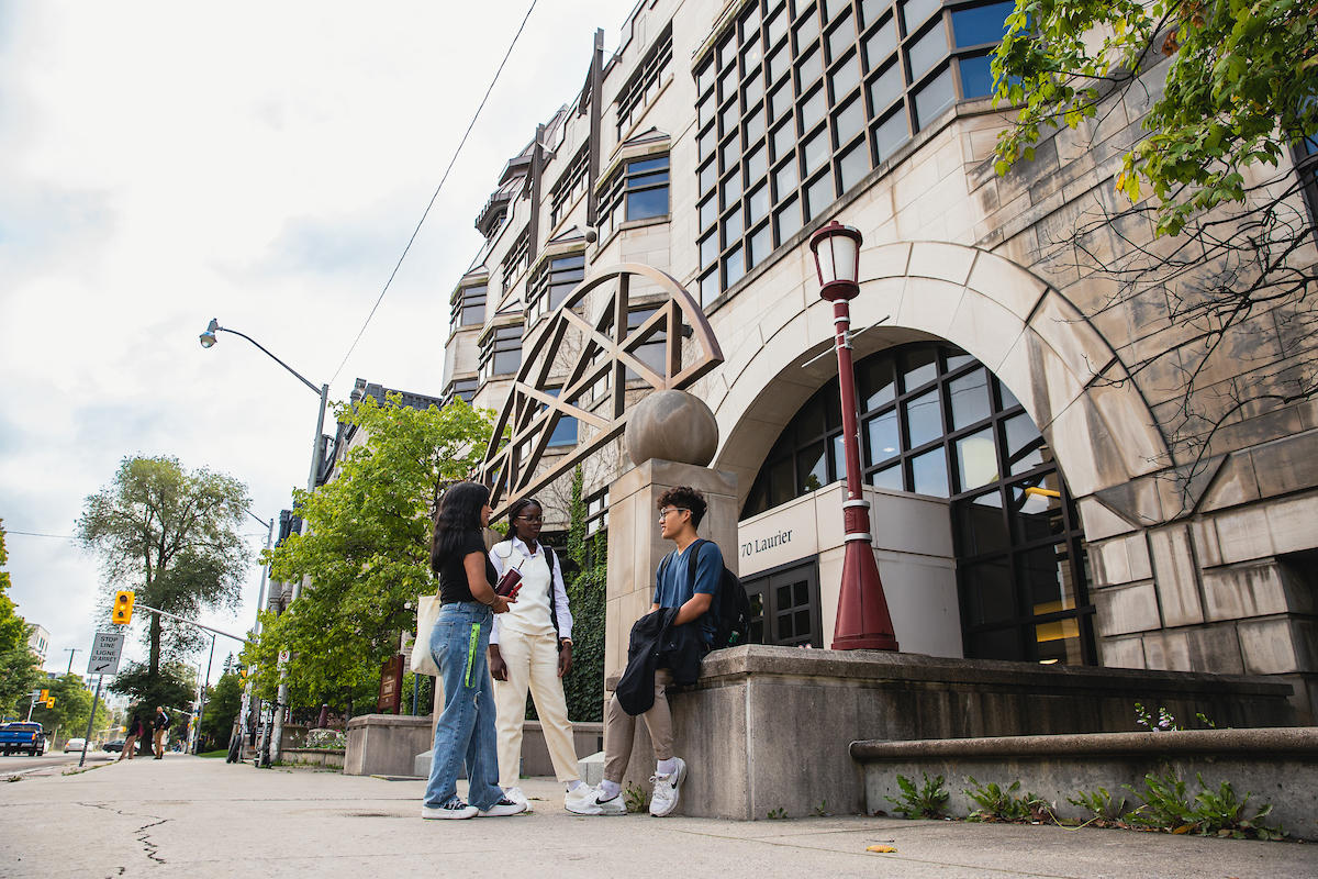 Students sitting outside of building on campus.
