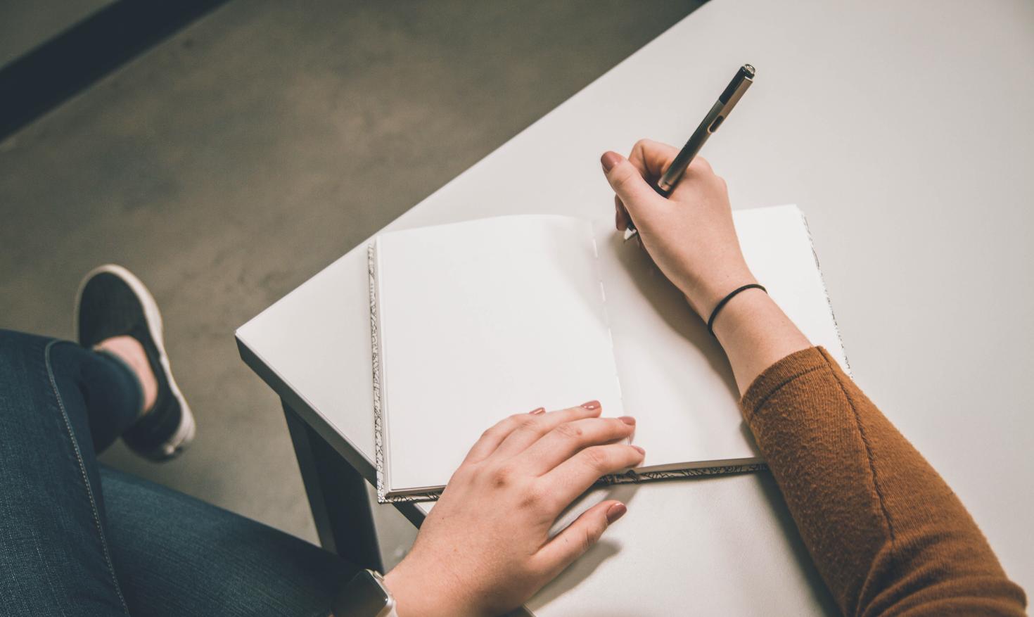 Person writing in notebook.
