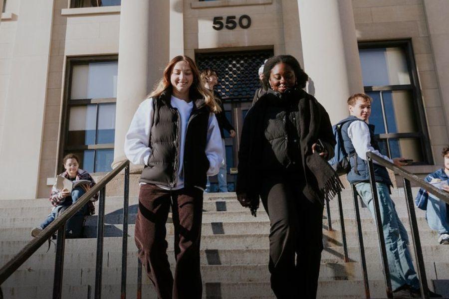Two students walking down the stairs at Tabaret.