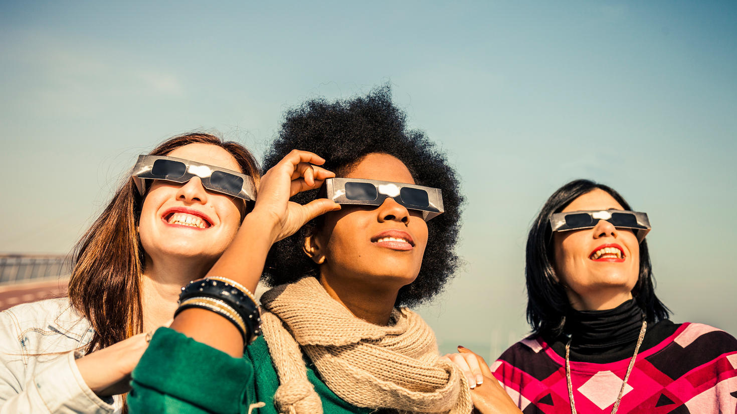 Group of friends looking to a solar eclipse.