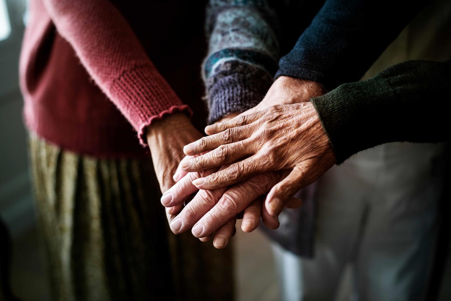Three hands joined atop one another