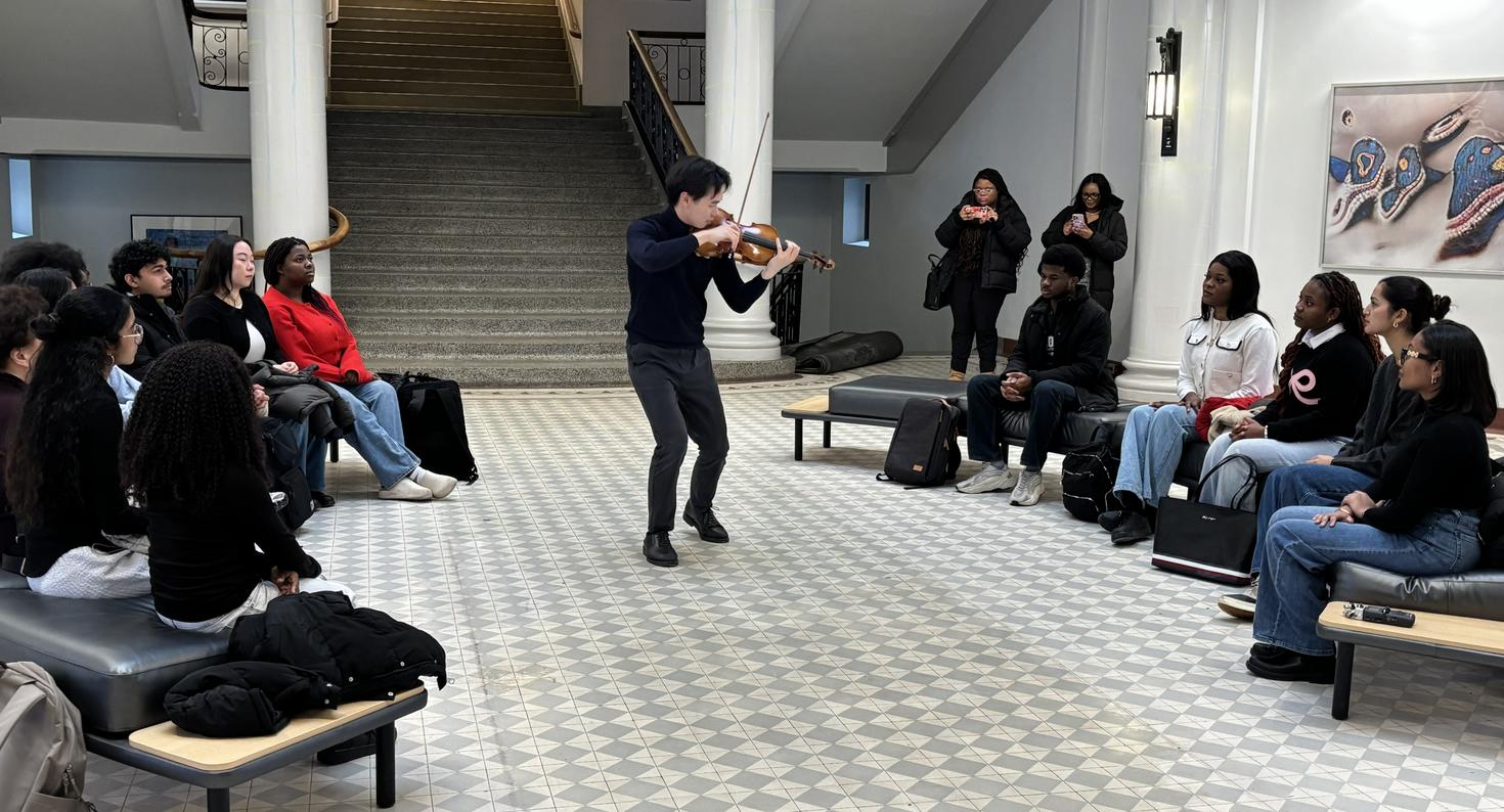 Timothy Chooi playing violin in the rotonde of Tabaret Hall.
