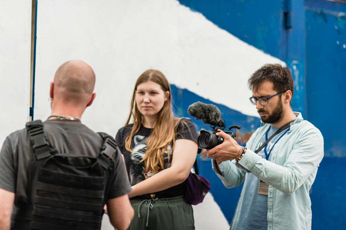 Two young journalists with a camera and microphone