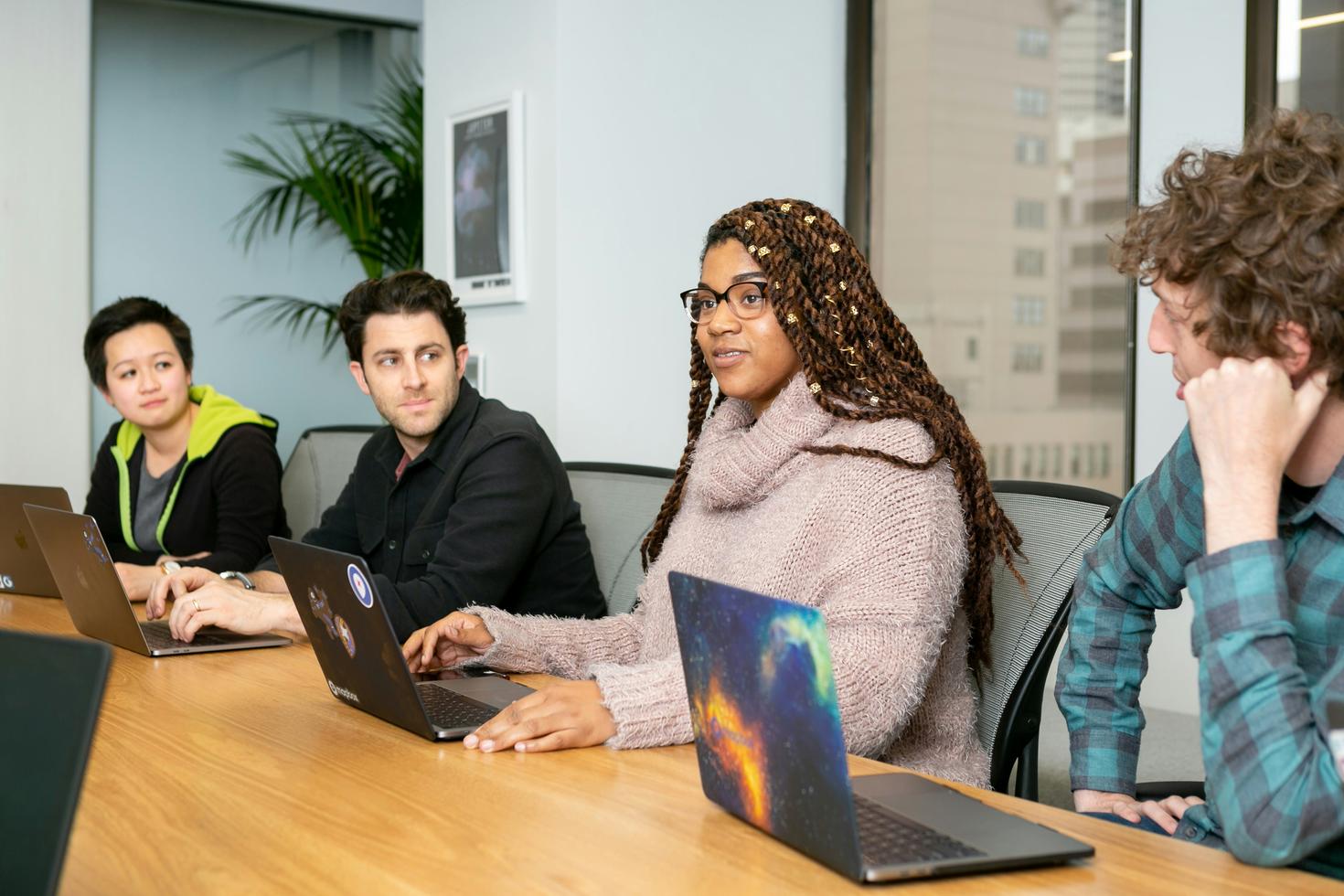 Two young women and men at work