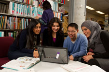4 people looking at a laptop