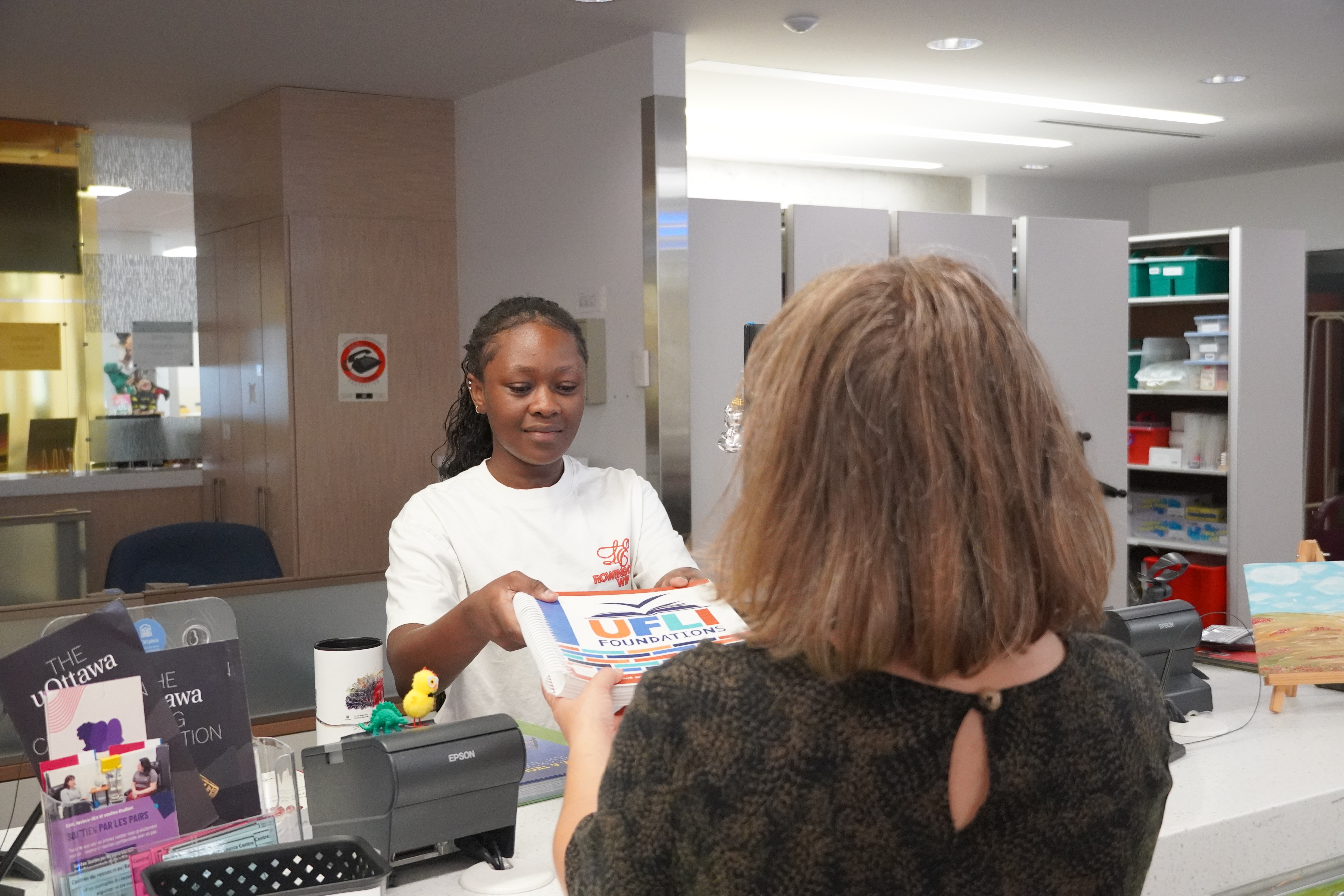 Receptionist giving a book
