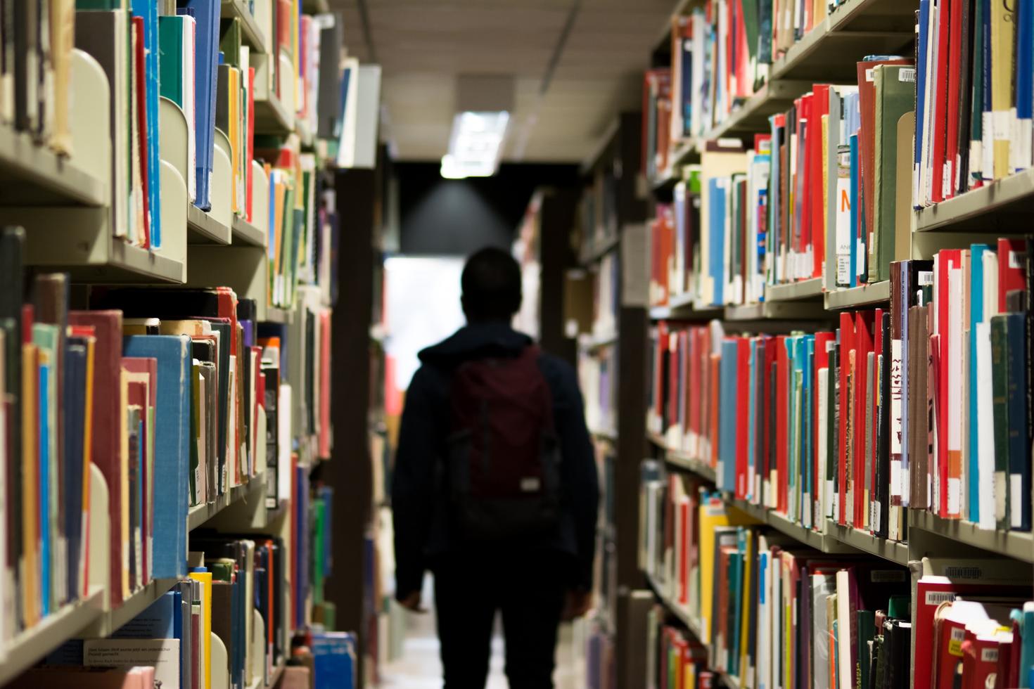 Person walking down an aisle in the library