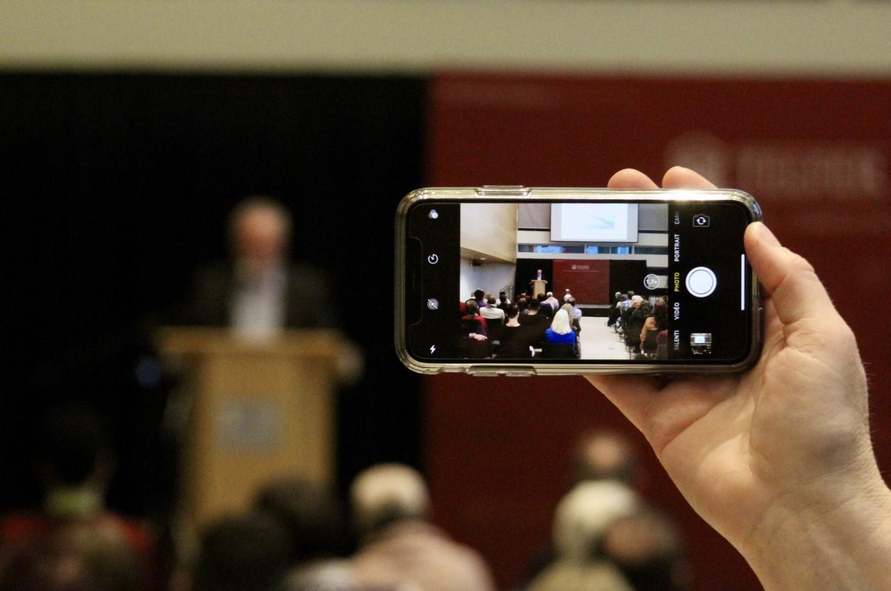 Person taking photo of research lecture