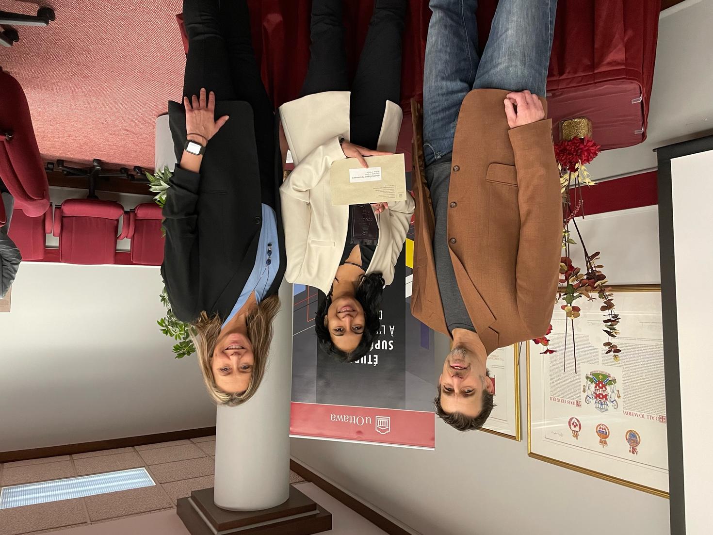 Winner with prize and two professors 