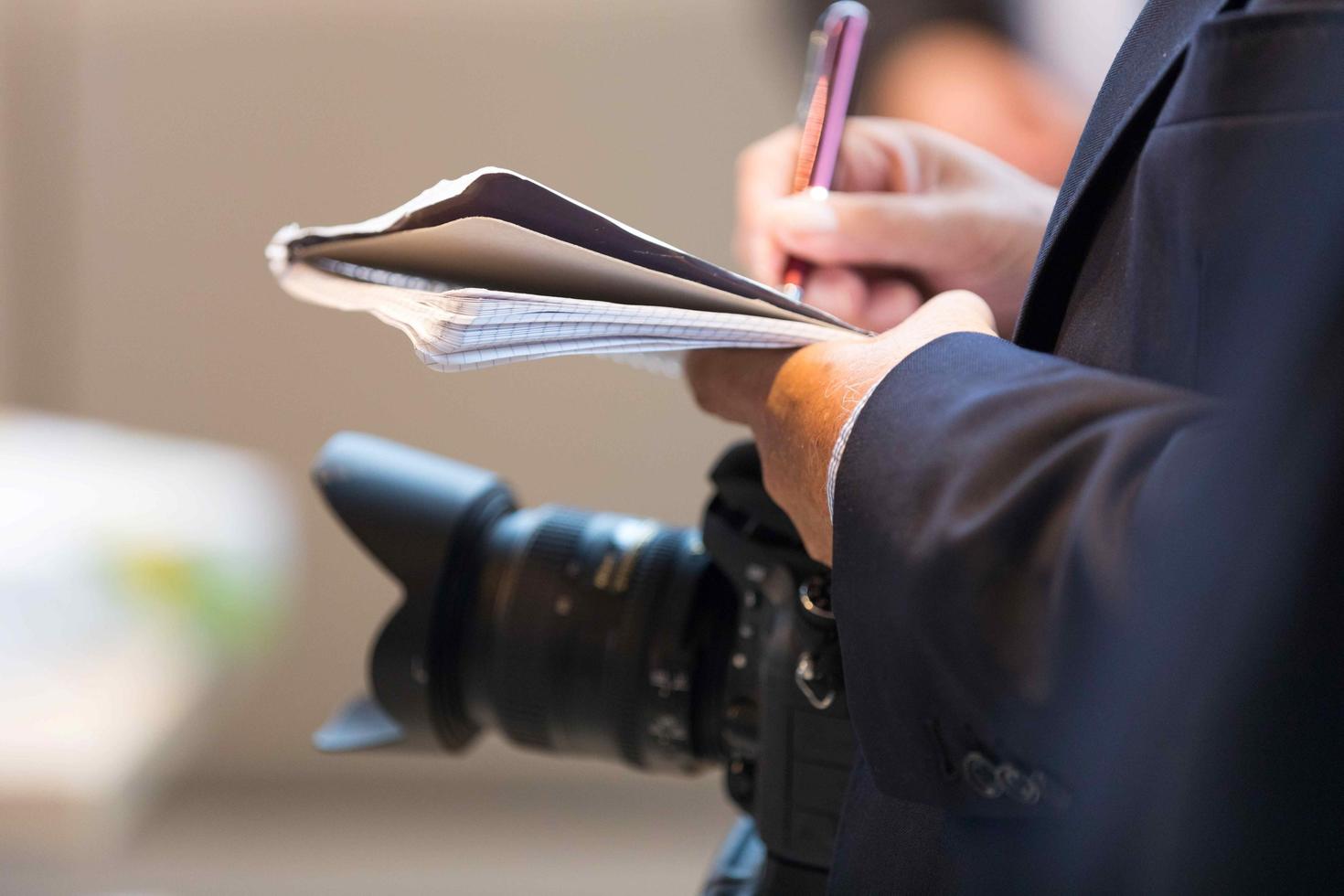 Journalist writing on notepad