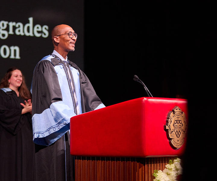 Dean Francis Bangou standing at a podium.