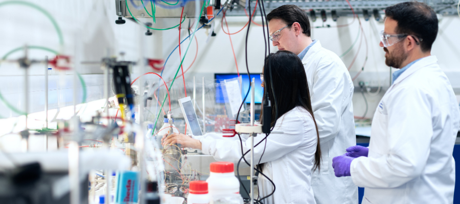  Engineering students working in biomedical lab with lab coats.