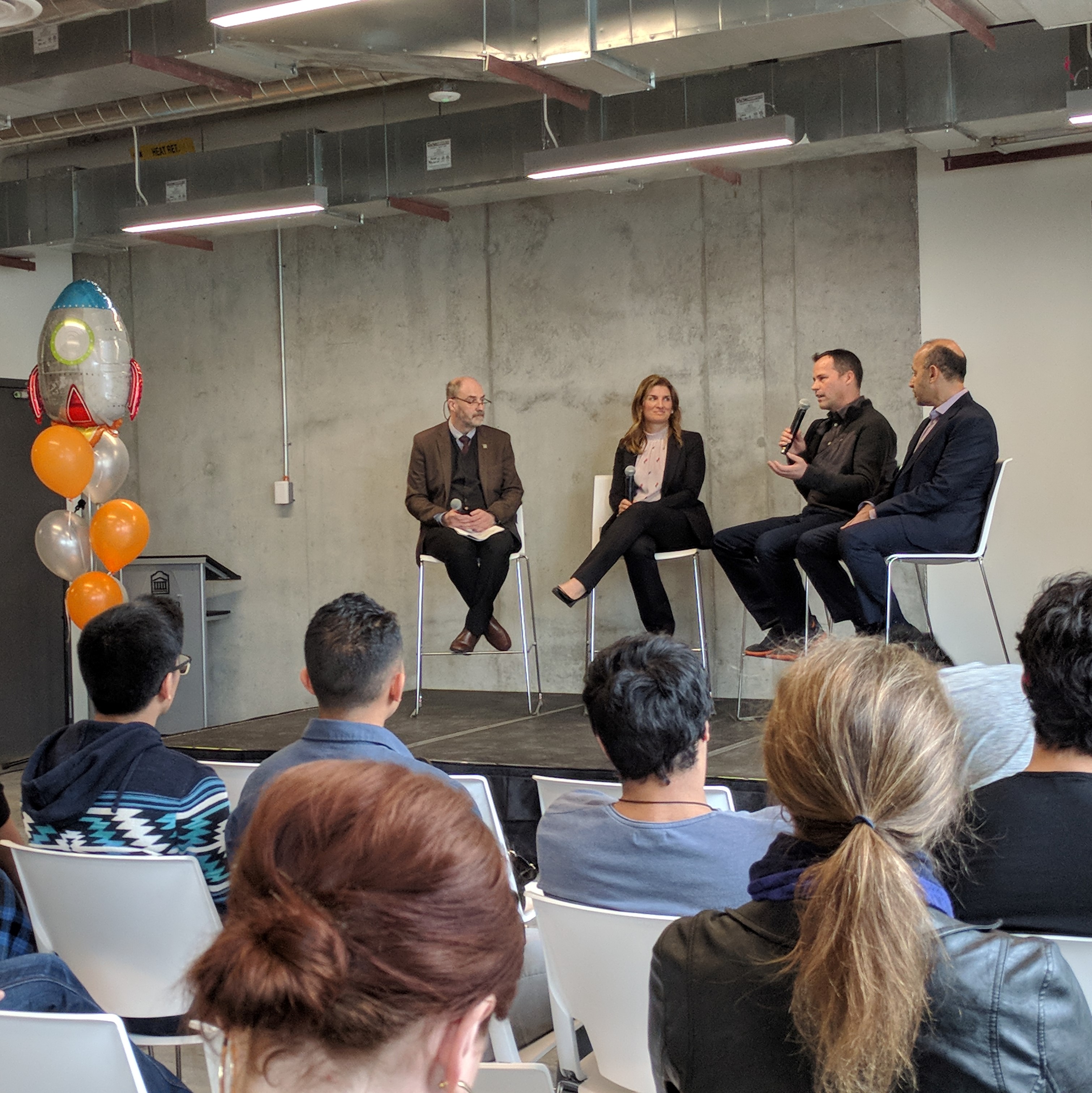 Speakers on a stage during a faculty event.