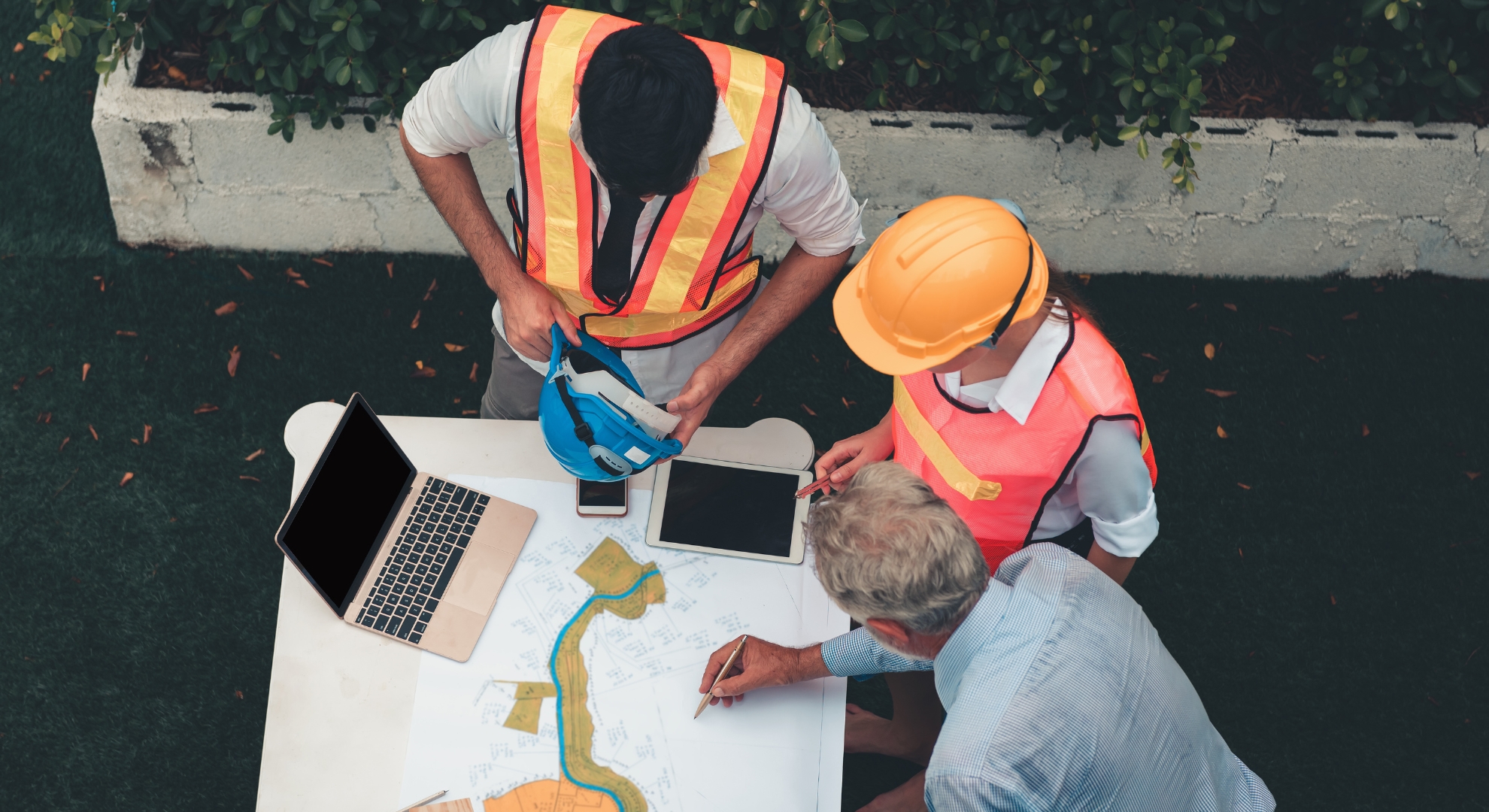 Engineers in discussion around a table on a construction site.