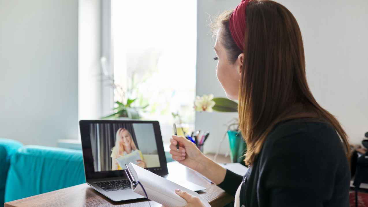 Person facing a laptop screen in a virtual meeting with a recruiter. 
