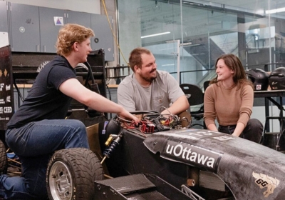 Two people and their mentor working on project.