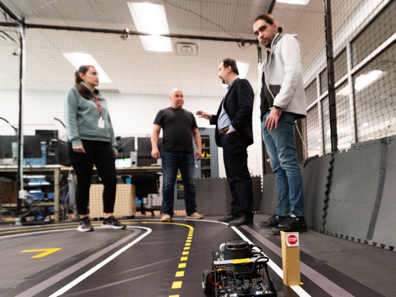 Burak Kantarci with group of people in autonomous vehicles lab.