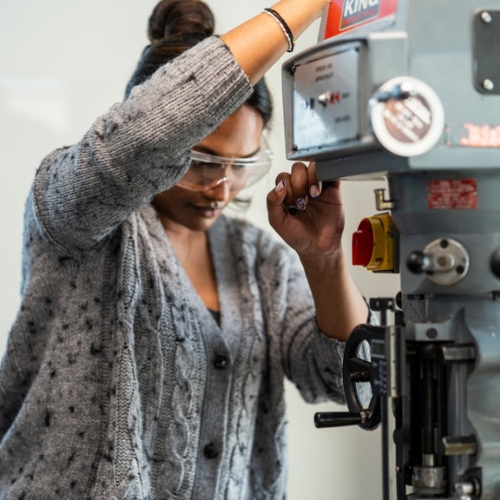Person using manufacturing equipment.