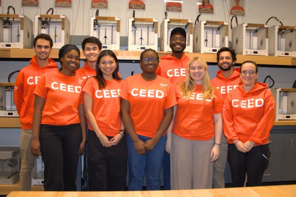 Smiling people wearing CEED shirts in the Makerspace.
