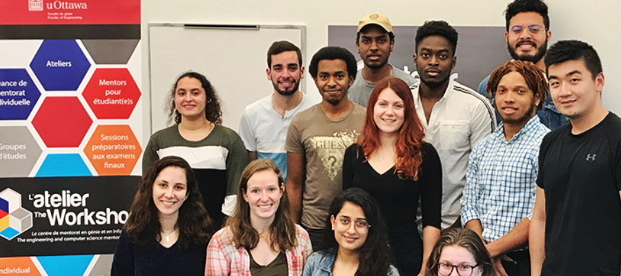 Group of students in front of banner for The Workshop.