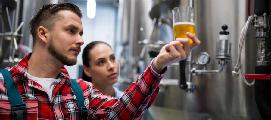 Two students study a beer in a lab.
