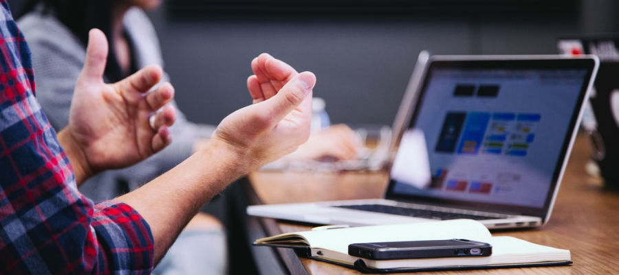 Someone interacting in front of a laptop at a meeting table